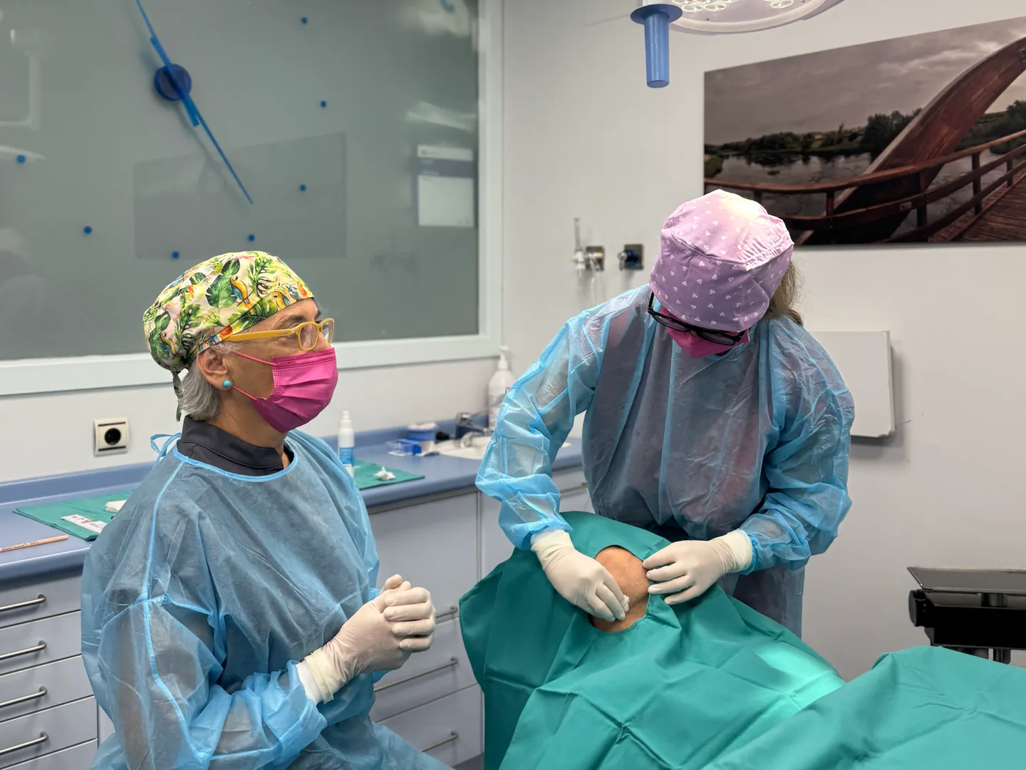 Dos profesionales con ropa clínica trabajando junto a un paciente cubierto en Lleida