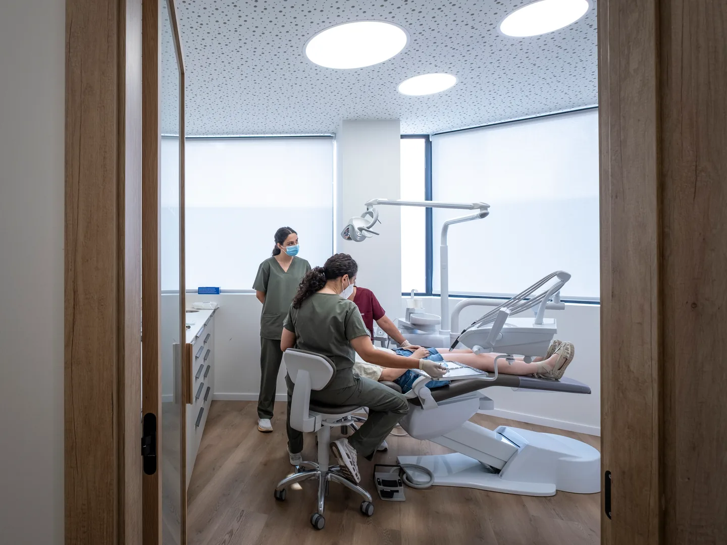 Atención dental a un paciente vista a través del cristal del gabinete de Tremp