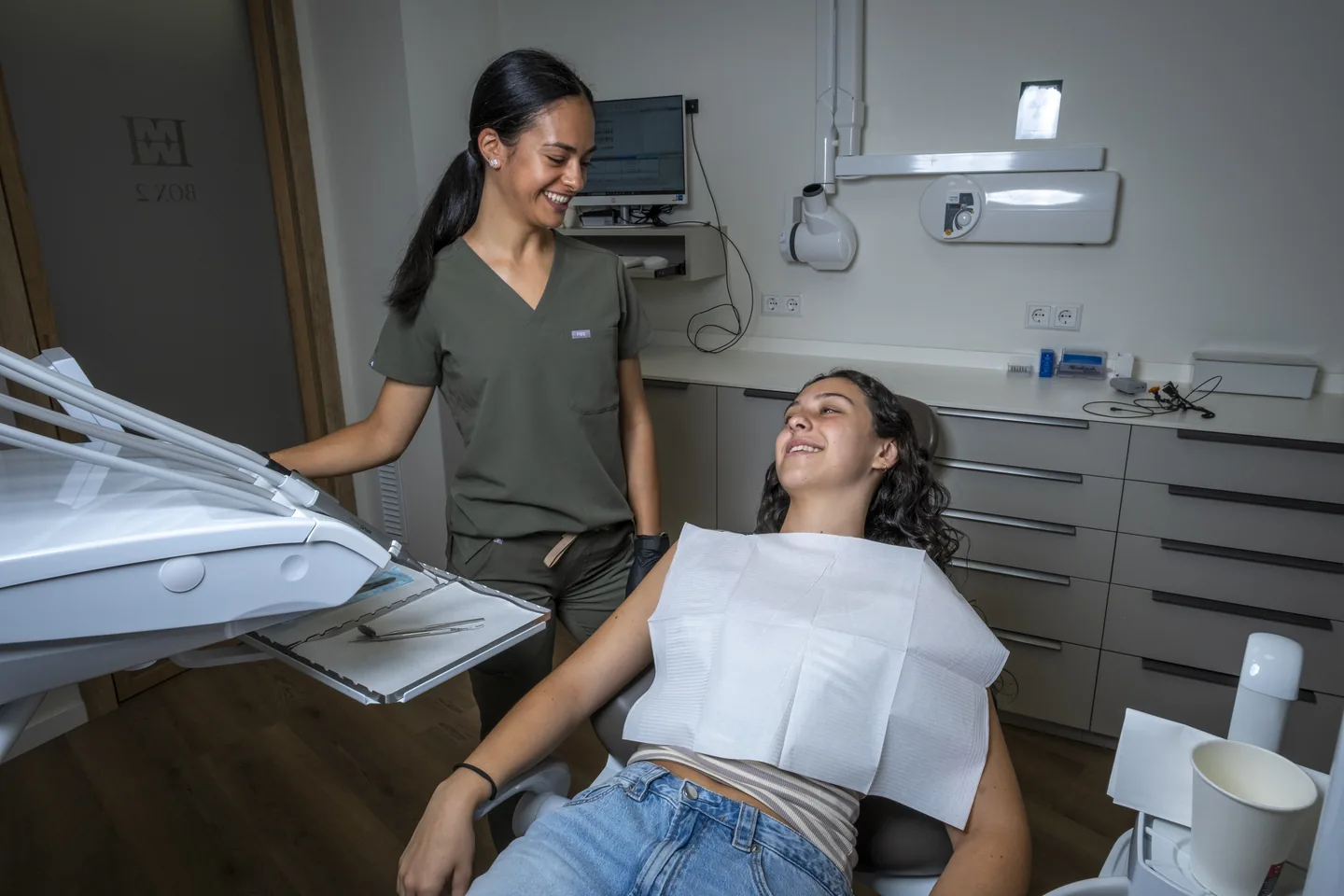 Professional i pacient conversant al costat de la butaca dental de Tremp