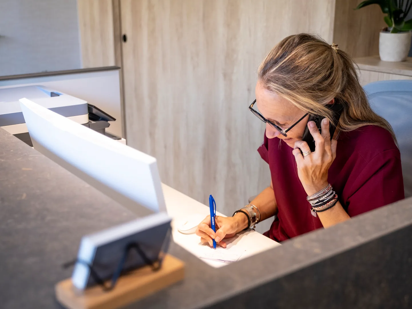 Recepcionista parlant per telèfon i escrivint al taulell de Tremp
