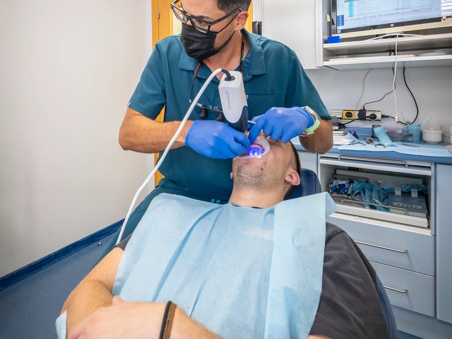 Professional treballant al costat d’un pacient a la butaca dental de Lleida