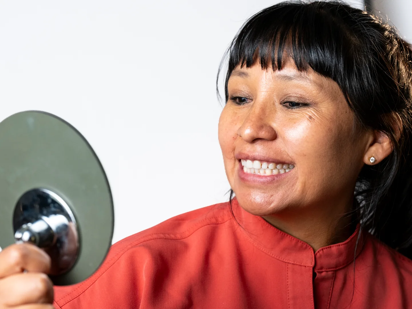Higienista sonriente con un espejo dental en la clínica de Lleida