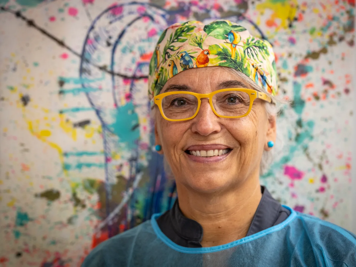 Professional amb roba clínica i gorra floral davant d’un mural a Lleida