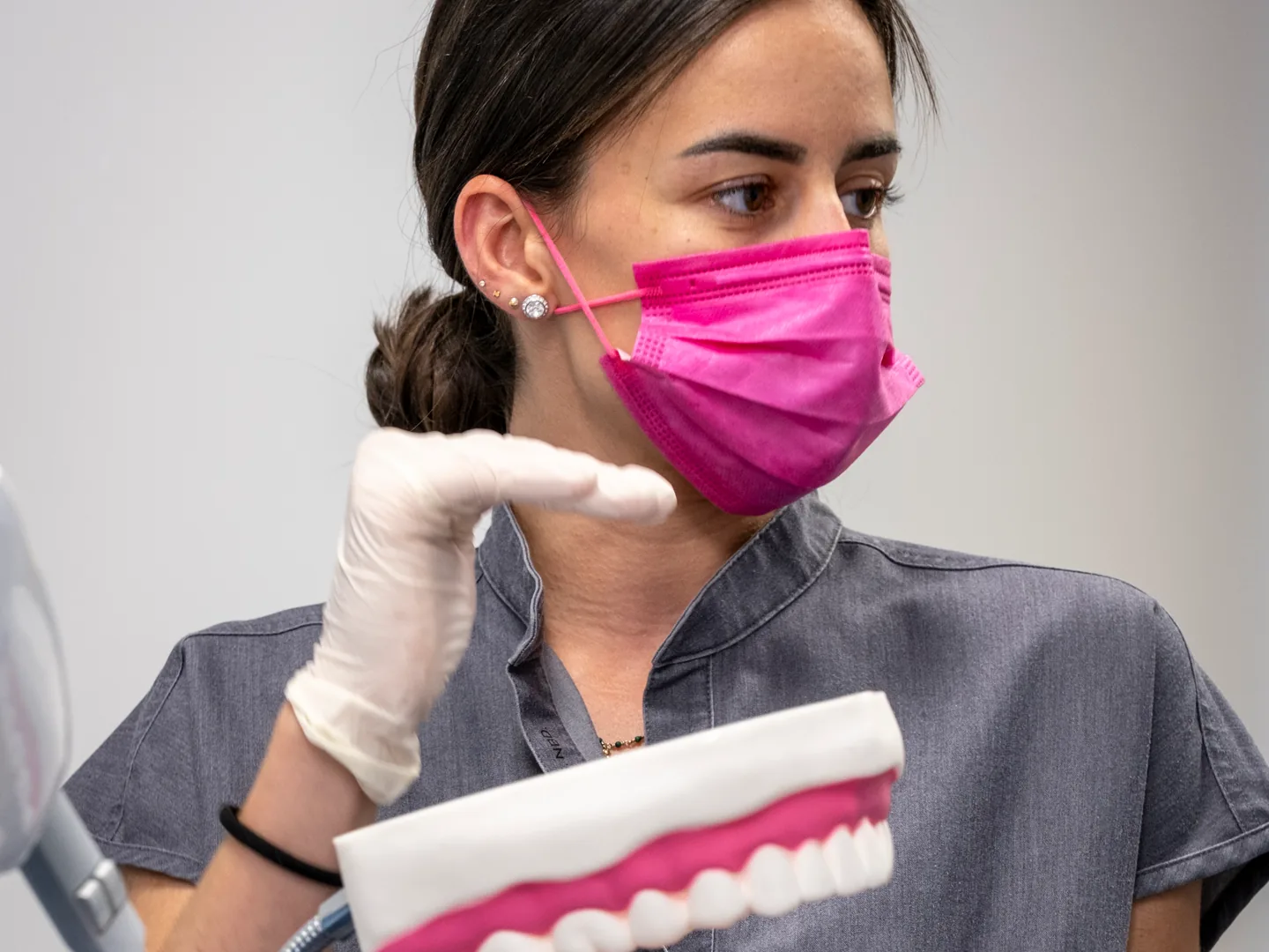 Profesional con mascarilla sosteniendo un modelo de dentadura en Lleida