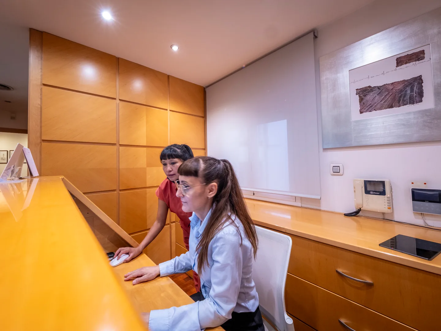 Dos profesionales trabajando en el mostrador de recepción de Lleida
